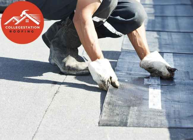 Commercial roofer installing membrane on roof.